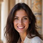 Portrait professionnel souriant de Chloé Martin, Travel Designer, avec un arrière-plan flou d'une cité historique européenne
